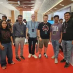 iFlair team members with Laracon India 2025 attendees in the event hallway