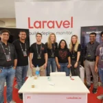 iFlair team posing with other attendees at the Laravel booth during Laracon India 2025