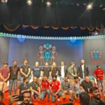 Group photo of Laracon 2025 attendees on stage in front of the event backdrop